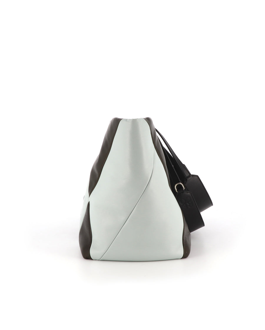 RECO Paris TRIXI bag in brown and light blue leather, worn by a woman as a functional and stylish tote.